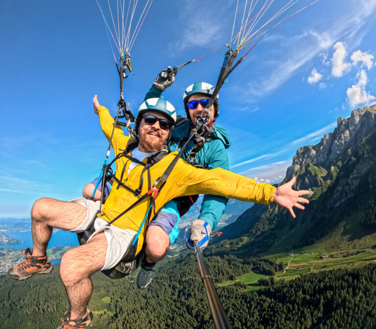 Tandem paragliding passenger in yellow jacket enjoying the view near Pilatu