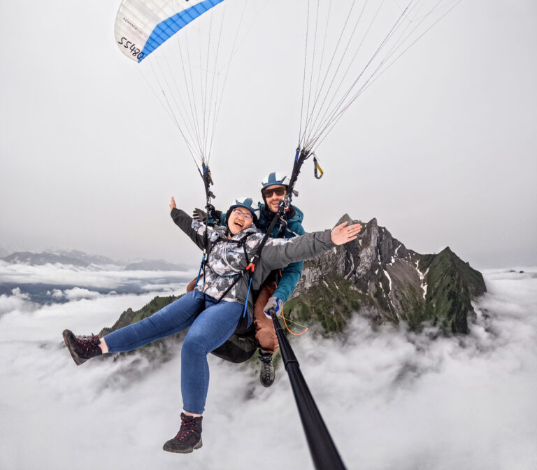 Tandem paragliding above clouds with mountain peaks near Mt. Pilatus
